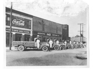 old augusta coca cola factory with trucks parked in front